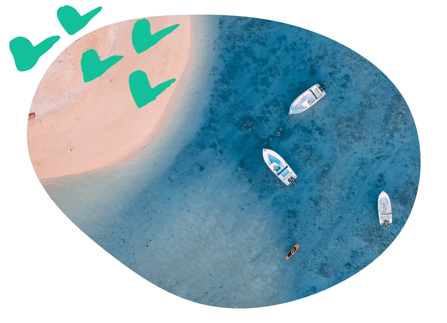 Three small motorboats anchored in shallow blue water off a sandy beach, seen from directly overhead