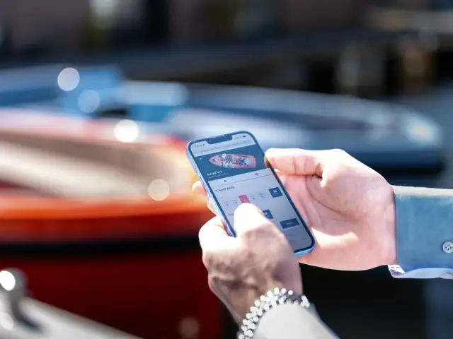 Een boot boeken op een telefoon aan de kade