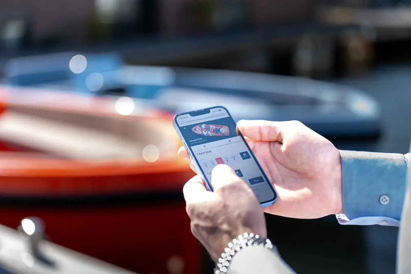 Au bord du quai, une date choisie sur le téléphone pour réserver un bateau