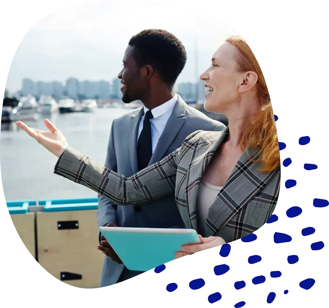 Two colleagues talking and laughing beside a moored boat