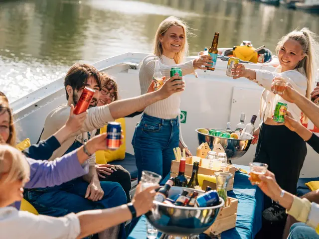 A group raising their drinks on an open tour boat