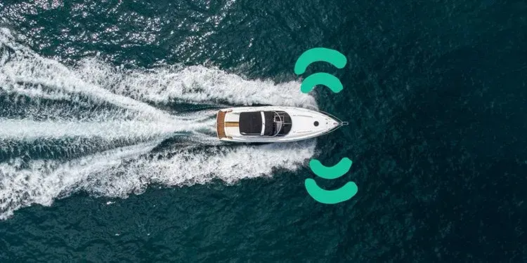 Een varend motorjacht van boven gezien, met signaalmarkeringen die laten zien dat het gevolgd wordt