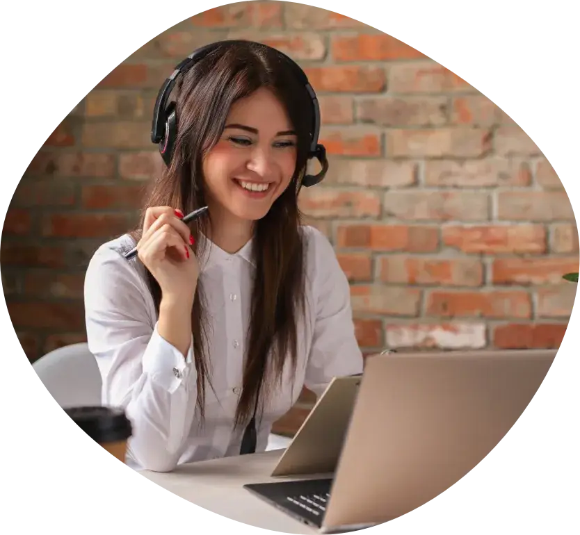 A woman wearing a headset at a desk in a brick-walled office
