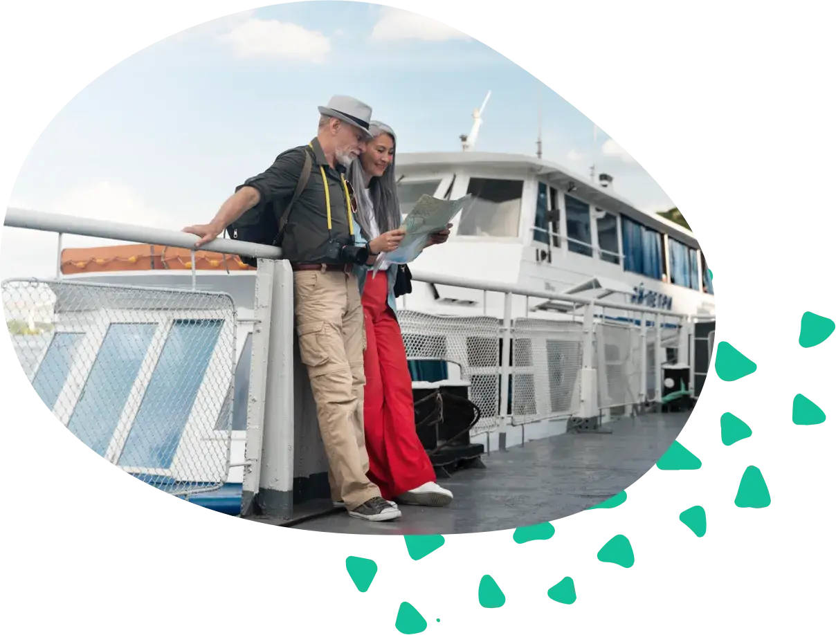 An older couple with a map and a camera at the rail of a passenger boat