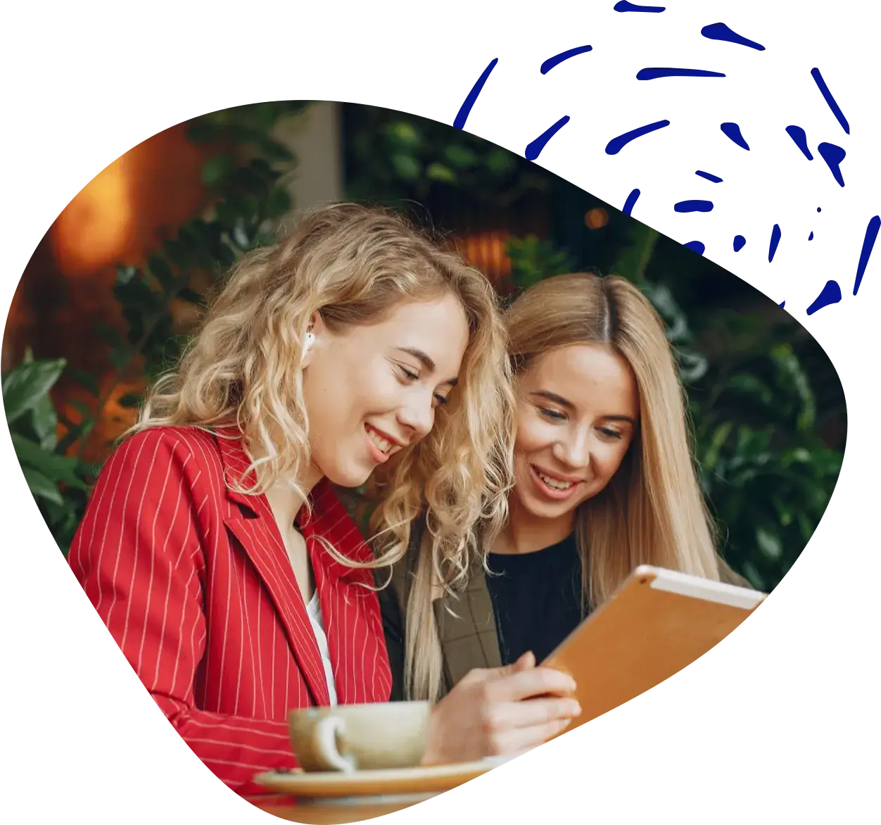 Two women looking at a tablet together, laughing