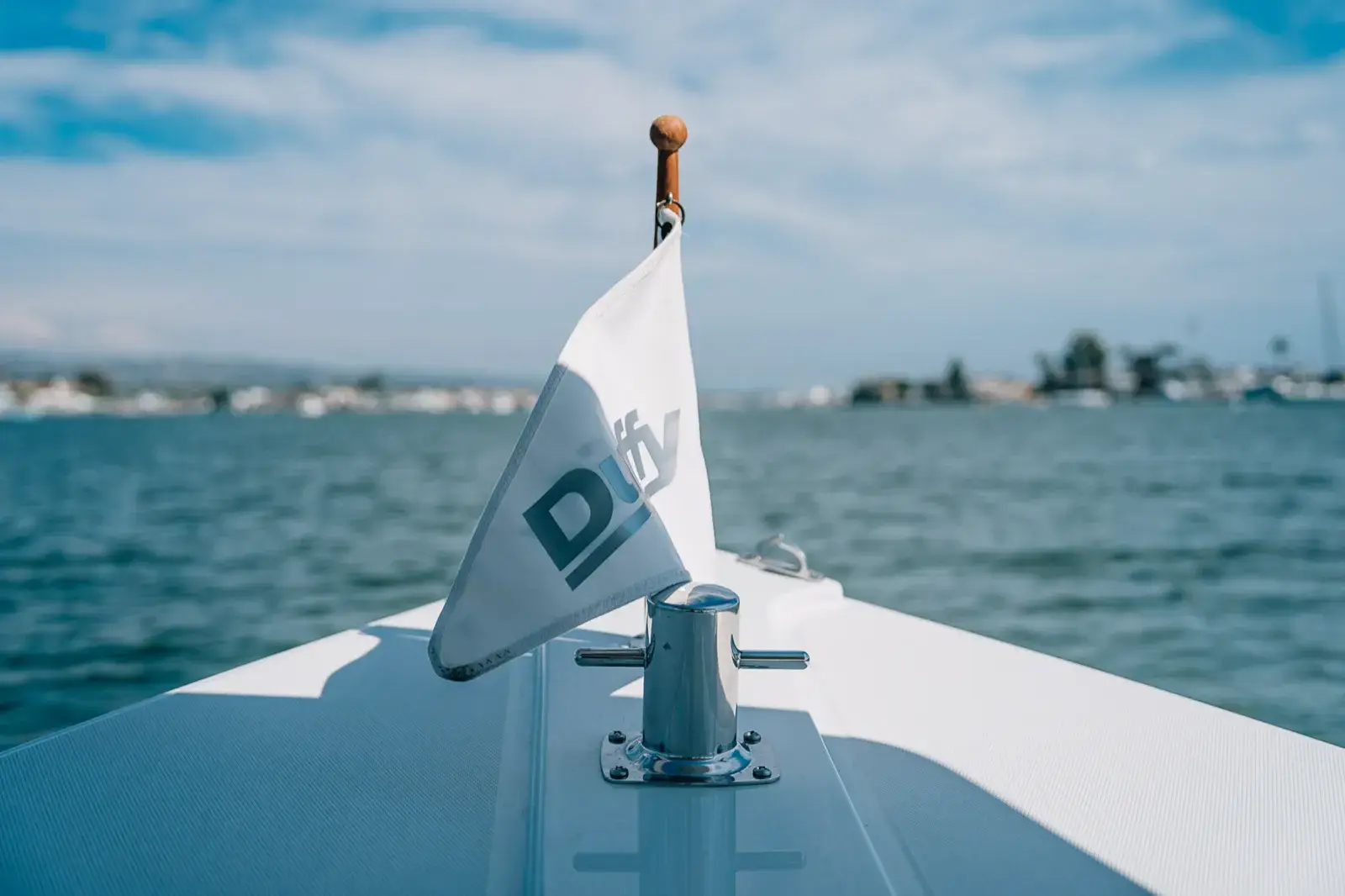 The Duffy flag on the bow of an electric boat, out on the water in Newport Beach