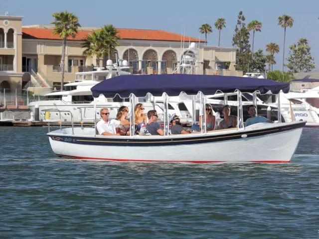 Friends under the blue canopy of a Duffy electric boat on Newport Harbor