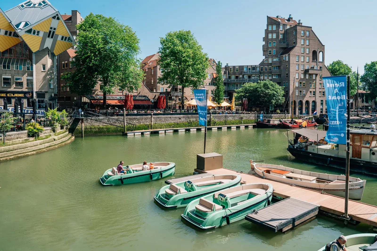 Des bateaux à moteur ouverts, verts, à leur quai dans l'Oude Haven de Rotterdam, l'un d'eux part en sortie