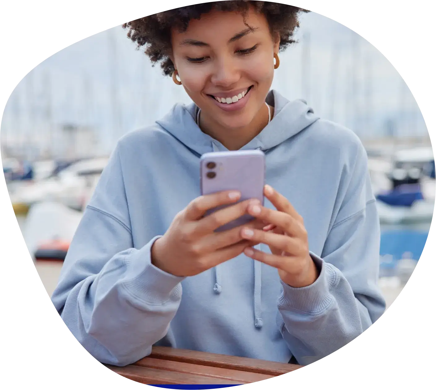 A woman smiling at her phone