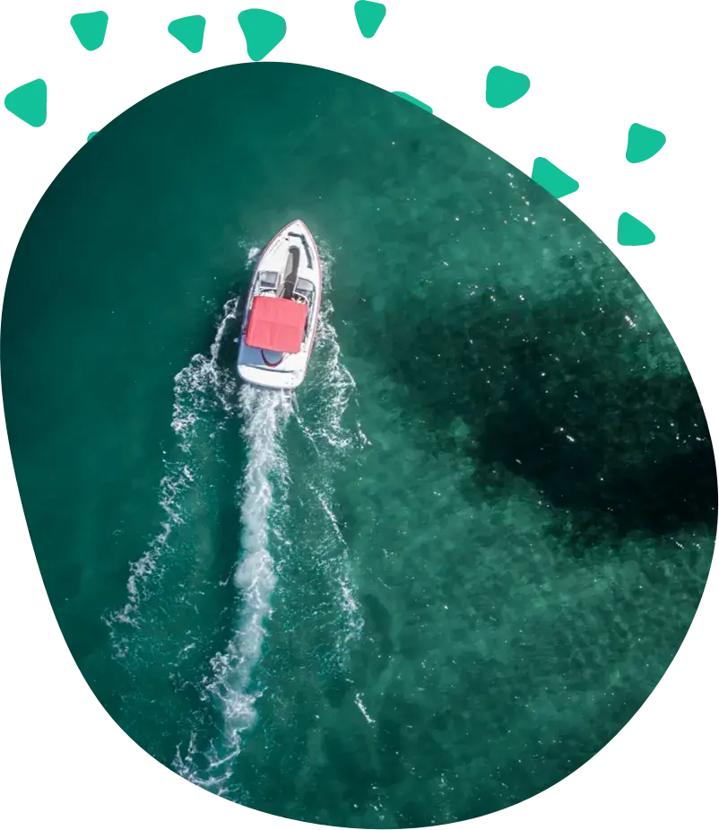 A small boat under way on dark green water, seen from above