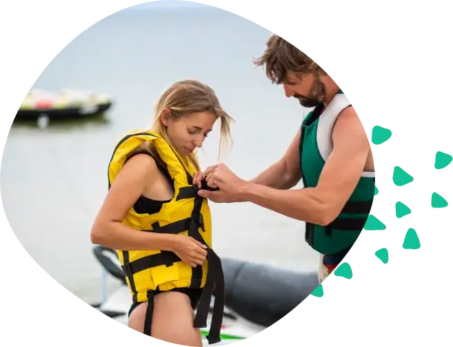 A man helping a woman fasten her life jacket