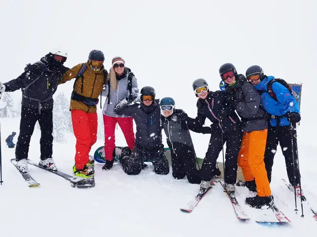 The Let's Book team together on a snowy ski slope, in helmets and goggles