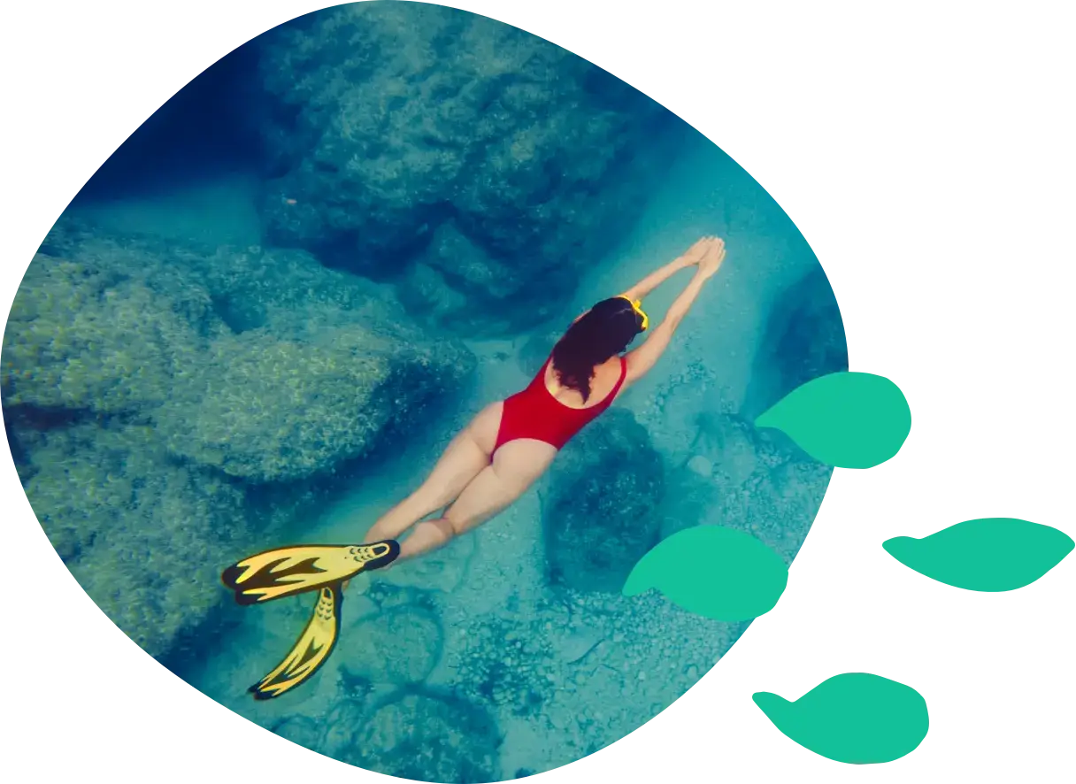 A woman snorkeling in clear turquoise water, seen from above